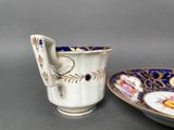 a cup and saucer sitting next to each other on a table