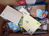a cardboard box filled with various items and a notepad