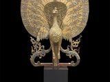 an image of a golden peacock statue on a black background