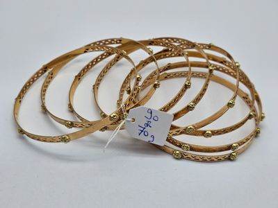 un lot de six bracelets de couleur dorée, avec une étiquette de prix