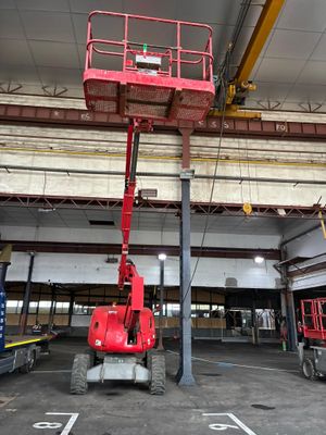 un homme sur une nacelle élévatrice dans un grand immeuble