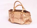 beige leather handbag on a white background