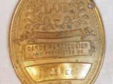 une vieille médaille d'or ornée d'un ruban, posée sur un tissu blanc