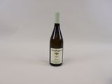 une bouteille de vin posée sur une table blanche