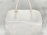 a white leather handbag sitting on top of a marble counter