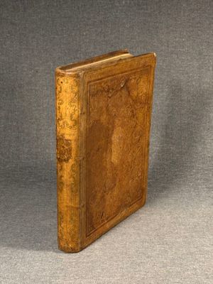 an old book sitting on top of a table next to a gray background