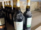 plusieurs bouteilles de vin sont alignées sur une étagère en bois