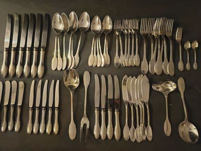 un grand nombre de cuillères et de fourchettes disposées sur une table