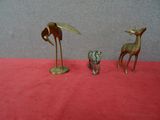 deux figurines d'animaux en laiton sur un fond rouge