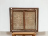 a painting on a easel with a piece of wood on it