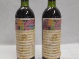 two bottles of wine sitting on top of a table next to each other