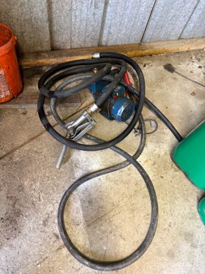 a green hose and a green blow dryer on the floor