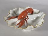 a red lobster in a shell shaped dish on a white table