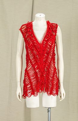 a mannequin with a red top on a stand