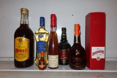 Des bouteilles d'alcool sont alignées sur une étagère à côté d'une boîte rouge