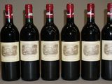 six bouteilles de vin sont alignées sur une table