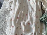 a baby laying on a bed next to a pile of clothes