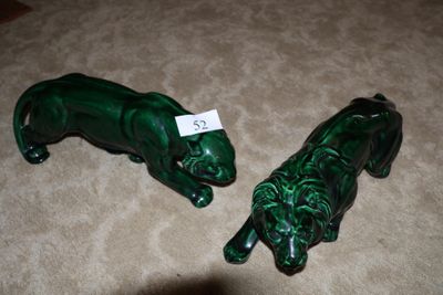 deux figurines vertes représentant des lions, posées par terre