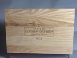 La boîte en bois, posée sur une table, contient une bouteille de vin.