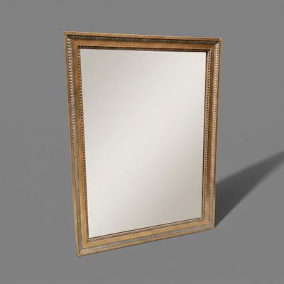 un miroir à cadre doré posé sur un meuble gris
