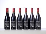 six bottles of red wine lined up in a row