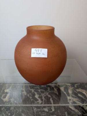 a brown vase with a sticker on it sitting on a table
