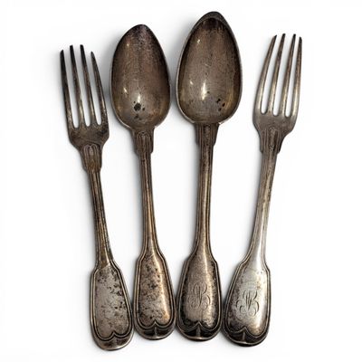 three silver spoons and a fork on a white surface