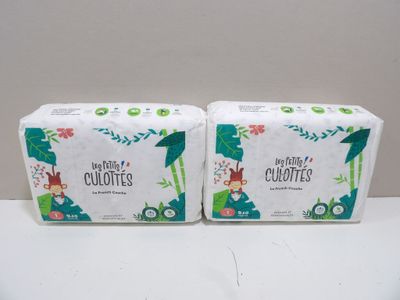 two boxes of baby diapers sitting on top of a table