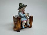 a small figurine of a boy sitting on a bench
