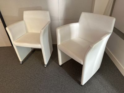 deux chaises blanches placées l'une à côté de l'autre dans une pièce