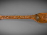 wooden spoon with a carved inscription on it that says, ' the great of the island '