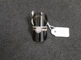 gros plan d'une bague sur une surface noire avec une étiquette de prix