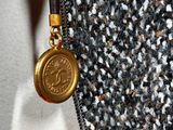 a close up of a purse with a gold coin on it