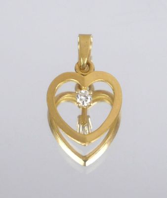 a close up of a heart shaped pendant with a diamond in the center