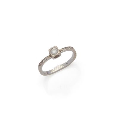 a close up of a diamond ring on a white surface