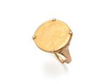 Gros plan sur une bague en or ornée d'une pièce de monnaie