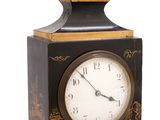 a black and gold clock sitting on a white surface