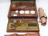 a small wooden box with a leather case and tools in it