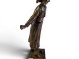bronze statue of a woman holding a tennis racquet on a marble base