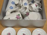 several cups and saucers are sitting in a box on a table