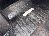 a dirty floor in a car with a sticker on it