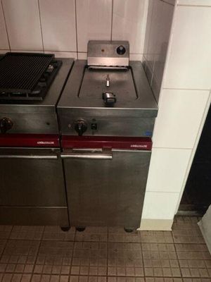 two stainless steel stoves in a kitchen with tile flooring