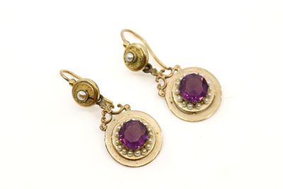 une photo d'une paire de boucles d'oreilles ornées de pierres violettes