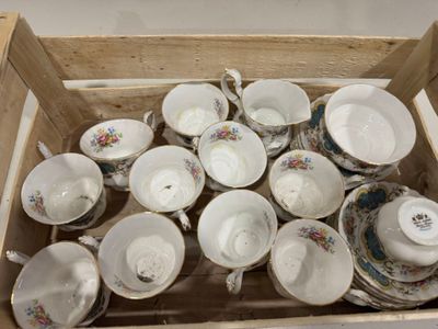 de nombreuses tasses et soucoupes dans une boîte en bois