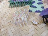 purple and green hair combs are on a woven table cloth