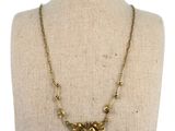 the necklace is made of brass beads and has a bird design on it