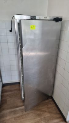 un réfrigérateur en acier inoxydable dans un coin de la salle de bains