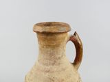 a brown vase with a handle sitting on a table