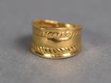 gros plan d'une bague en or sur une surface grise
