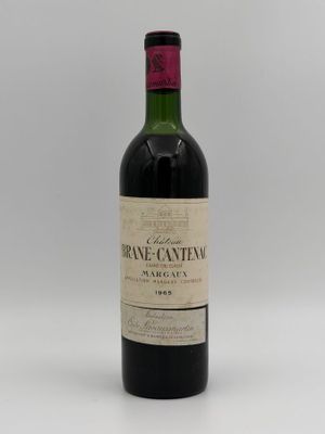 a close up of a bottle of wine on a white surface